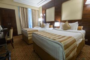 麦地那Ruve Al Madinah Hotel的酒店客房配有两张床和一张书桌