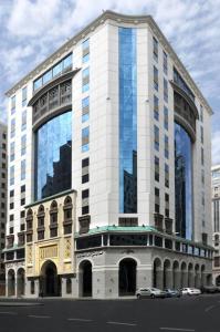 麦地那Ruve Al Madinah Hotel的城市街道上一座高大的白色建筑,窗户