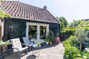 布尔坦赫城Ster van Bourtange的一个带椅子的花园棚和一个庭院