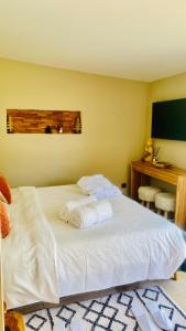 索利耶蓬Le Cocoon Lodge du Gapeau & Massage的一间卧室配有一张大床和毛巾