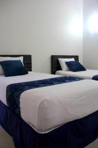 科利马Hotel Juarez 70的卧室内的两张床和蓝色枕头