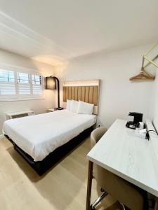 旧金山Nob Hill Motor Inn -Newly Updated Rooms!的一间卧室配有一张床、一张桌子和一张四柱床。