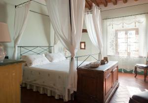 圣吉米纳诺Il Coltro的一间卧室设有天蓬床和窗户。