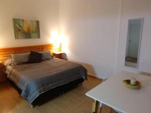 上格拉西亚Solar del Tajamar的一间卧室配有一张床、一张桌子和一面镜子