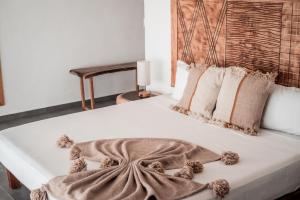 兹波利特Che Zipolite Hostel & Naked Beach Club的一张带毯子和枕头的大型白色床