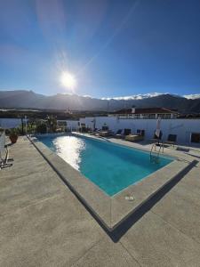 ArafoFinca la Pampa的一座游泳池,位于一座有阳光的建筑的顶部
