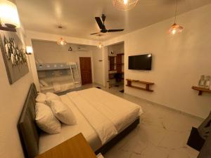 图杜Rihiveli Residence Thoddoo的一间卧室配有一张床和一台平面电视