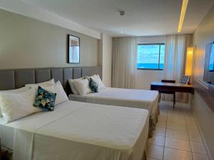 累西腓HY Apartments & Hotels的酒店客房配有两张床和一张书桌
