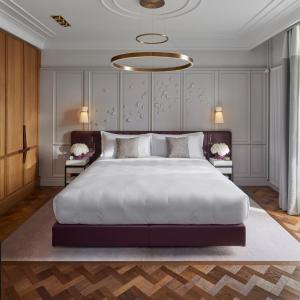 卢塞恩Mandarin Oriental Palace, Luzern的卧室配有一张白色大床和吊灯。