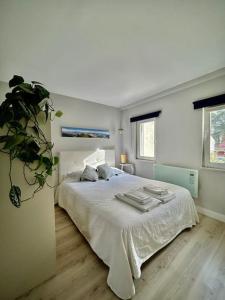 帕雷迪Charmoso estúdio perto da praia的卧室配有白色床和毛巾