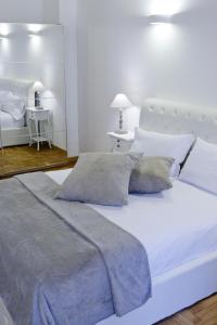 罗马里佩塔3号旅馆的白色卧室配有一张带枕头的大白色床