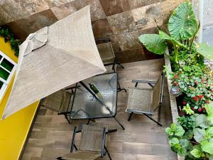 墨西哥城Hidden house的享有带椅子和遮阳伞的天井的顶部景致。
