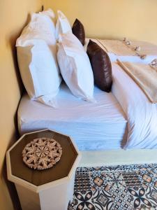 扎古拉Zagora Oasis Lodge的一张带许多枕头的床和一个托盘