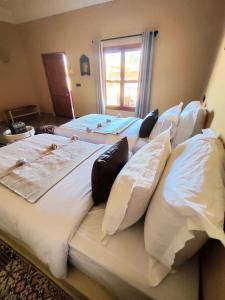 扎古拉Zagora Oasis Lodge的一间设有三张床和枕头的客房