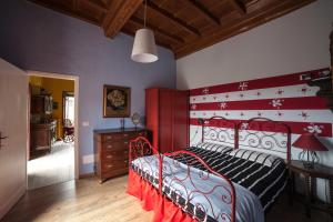 卡尼洛瑞维拉All'Antico Convento的一间在房间内配有红色和白色床的卧室