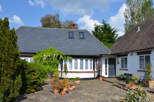查尔芬特－圣贾尔斯NEW - Beautiful, spacious Beechwood Lodge with lovely gardens的院子里有盆栽的白色房子