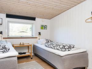 格莱斯堡10 person holiday home in Glesborg的一间卧室设有两张床和窗户。