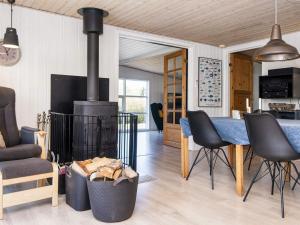 格莱斯堡10 person holiday home in Glesborg的客厅设有壁炉、桌子和椅子