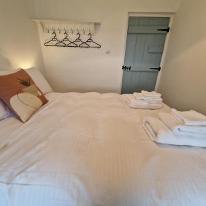 Knockfin Cross RoadsCoastal Charm Cottage的卧室配有白色床和毛巾