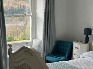 凯西克戴尔总馆西湖大酒店 的卧室配有床、椅子和窗户。