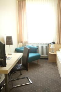 希尔德斯海姆伯格梅特卡佩旅馆的酒店客房配有一张床、一张书桌和一张沙发。