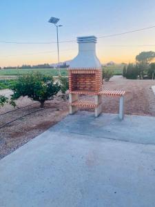 L'AldeaMas de Melonet Delta del Ebro的坐在田野旁人行道上的长凳