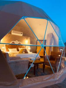 瓦迪拉姆Faisal Wadi Rum camp的帐篷配有一张床和一张桌子