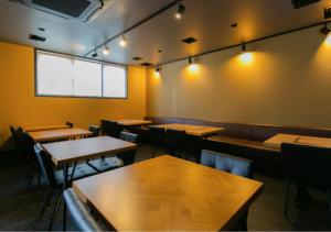 大阪Residence Saku的餐厅设有木桌和椅子及灯