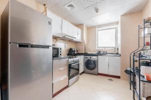 迪拜Great Gatsby's Home的厨房配有不锈钢冰箱和洗碗机