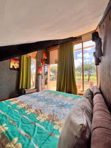 Oloitokitok Kilimanjaro view cabin-Amboseli的窗户客房内的一张大床