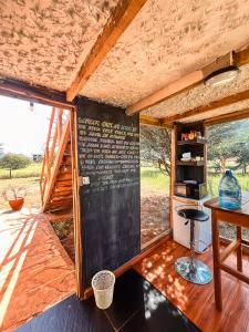 Oloitokitok Kilimanjaro view cabin-Amboseli的一间设有黑板、桌子和凳子的房间