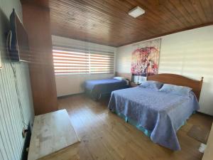 埃尔基斯科Habitaciones Mar Azul的一间卧室配有一张床、一张桌子和一台电视