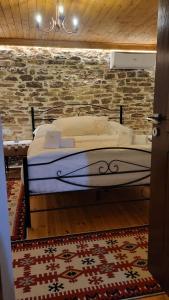 吉诺卡斯特Guest House Hasko的砖墙房间的一个床位