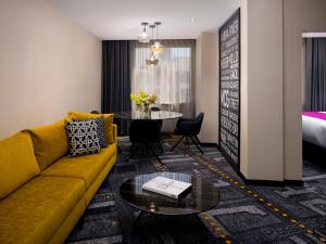 墨尔本Pullman Melbourne City Centre的客厅配有黄色的沙发和桌子