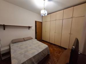 圣保罗Casa Vila da Saúde, aconchegante com 2 garagens e 2 quartos的一间卧室配有一张床、橱柜和椅子