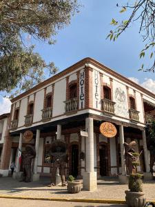 卡尔波镇Hotel El Aguila, Villa del Carbón的前面有两座雕像的建筑