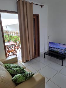 巴拉多库努Apartamento em Barra do Cunhaú的带沙发和平面电视的客厅
