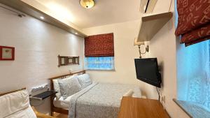 香港优閒渡假屋的小房间设有床铺和电视