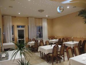 奥什恰德尼察凯瑟拉旅馆的一间设有桌椅的用餐室和天花板上的球