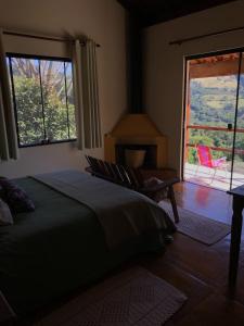布埃诺布兰当Pousada Pedra Grande的一间卧室设有一张床、一个窗口和一把椅子
