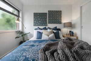 墨尔本VAQUAY Contempo In Flemington的一间卧室设有蓝色的床和窗户。