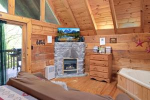 加特林堡Cozy Cabin! Hot Tub, King Bed, Fireplace, & Pool的客厅设有壁炉和电视。