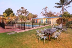 莱克斯恩特伦斯Ocean Views Motel Lakes Entrance的一个带桌椅的庭院和一个游泳池