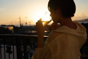 本部Jacuzzi Terrace Okinawa IMS的日落时分喝一杯酒的年轻女人