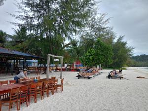瓜隆岛SCARLET SAILS BUNGALOW的一群坐在海滩桌子上的人