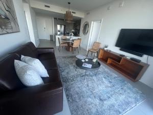 迈阿密APARTMENT FOR RENT 2 BED 2 BATH 1 Parking DOWNTOWN DORAL的带沙发、电视和桌子的客厅