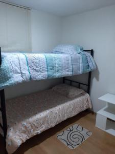 利马Piso 21 - Habitaciones en departamento - compartido的一间卧室配有双层床,下方配有一张搁脚凳