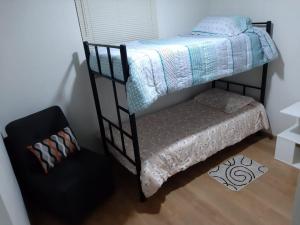 利马Piso 21 - Habitaciones en departamento - compartido的一间卧室配有双层床和椅子