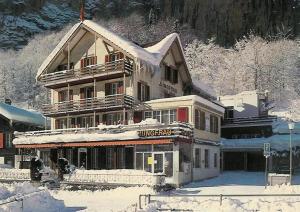劳特布龙嫩Hotel Restaurant Jungfrau的前方有积雪覆盖的大建筑
