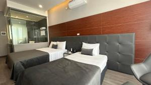河内Mango Hotel - Ha Noi Railway station的酒店客房,设有两张床和镜子